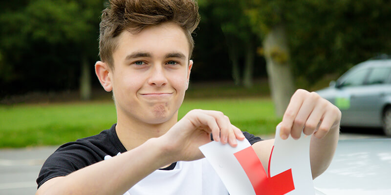 Teenage boy ripping L plate in half