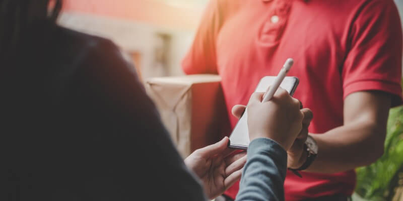 Hand signing for parcel from postman